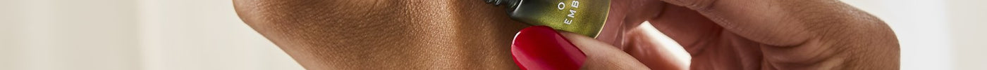 Hands holding two Discovery Collection oud rollerballs