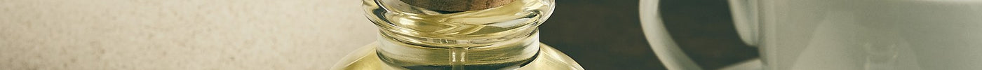 Royal Oud elixir beside a cup and saucer on marble