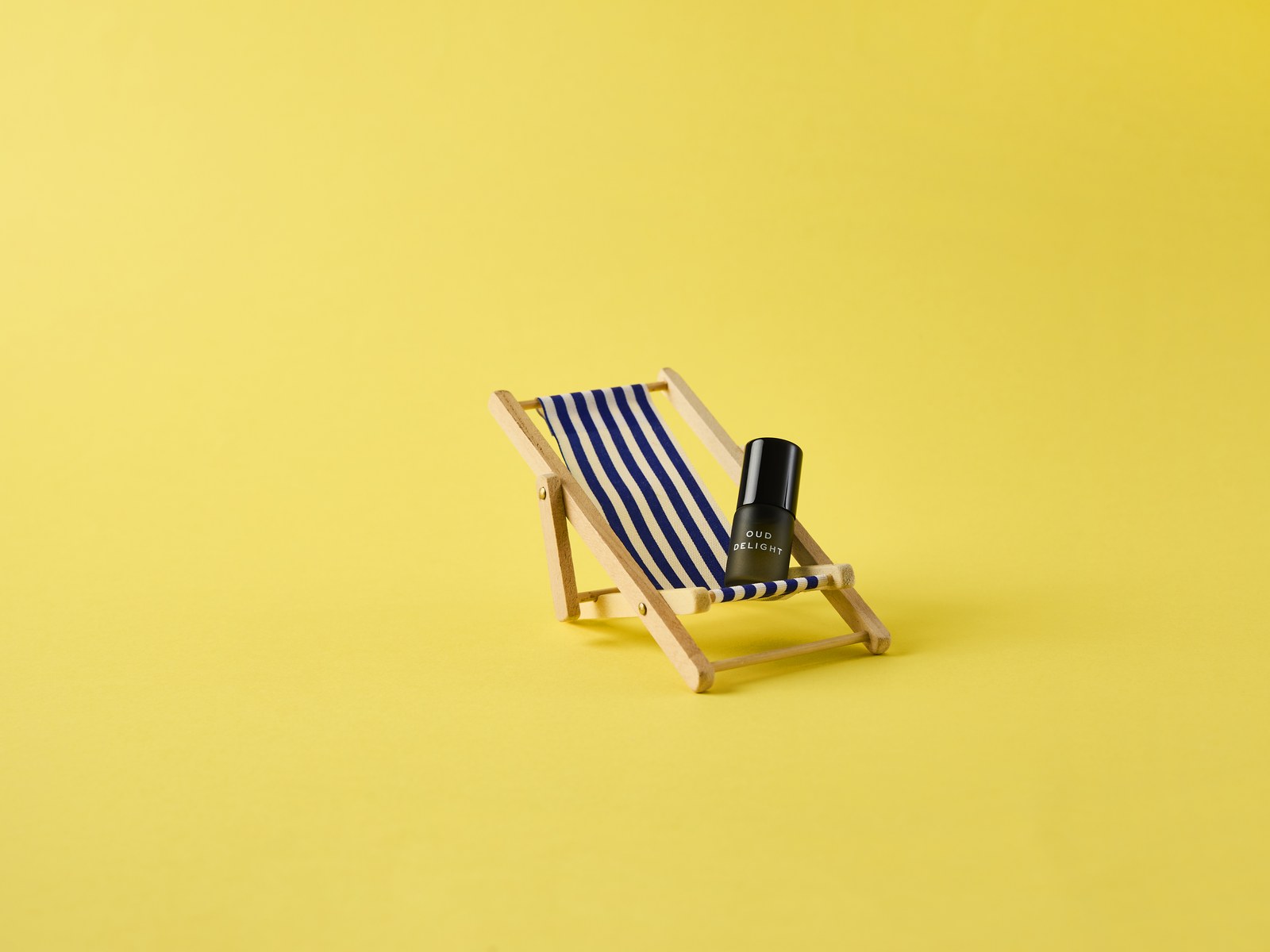Oud rollerball on a miniature striped deckchair