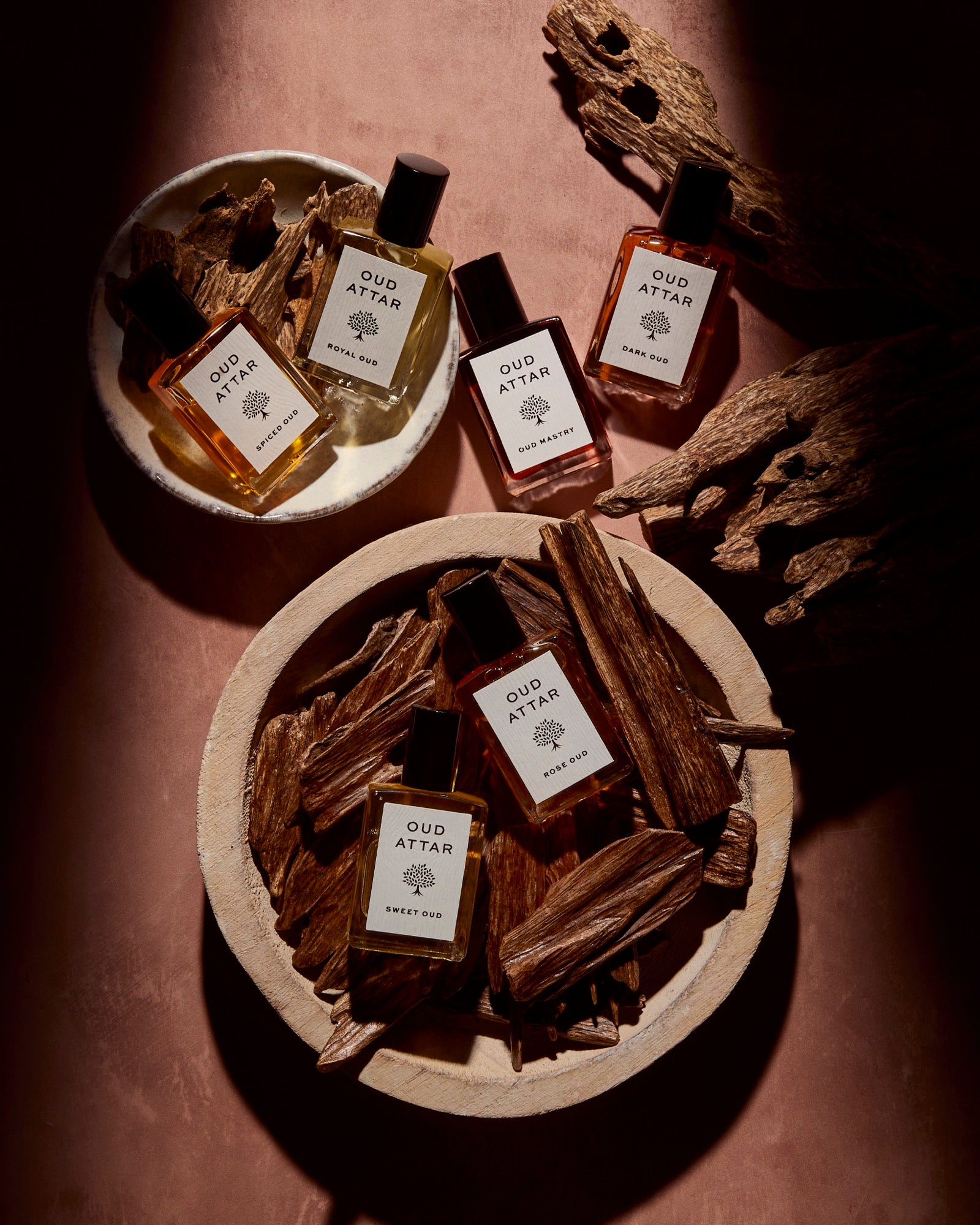 Oud Attar bottles nestled in bowls of oud chips